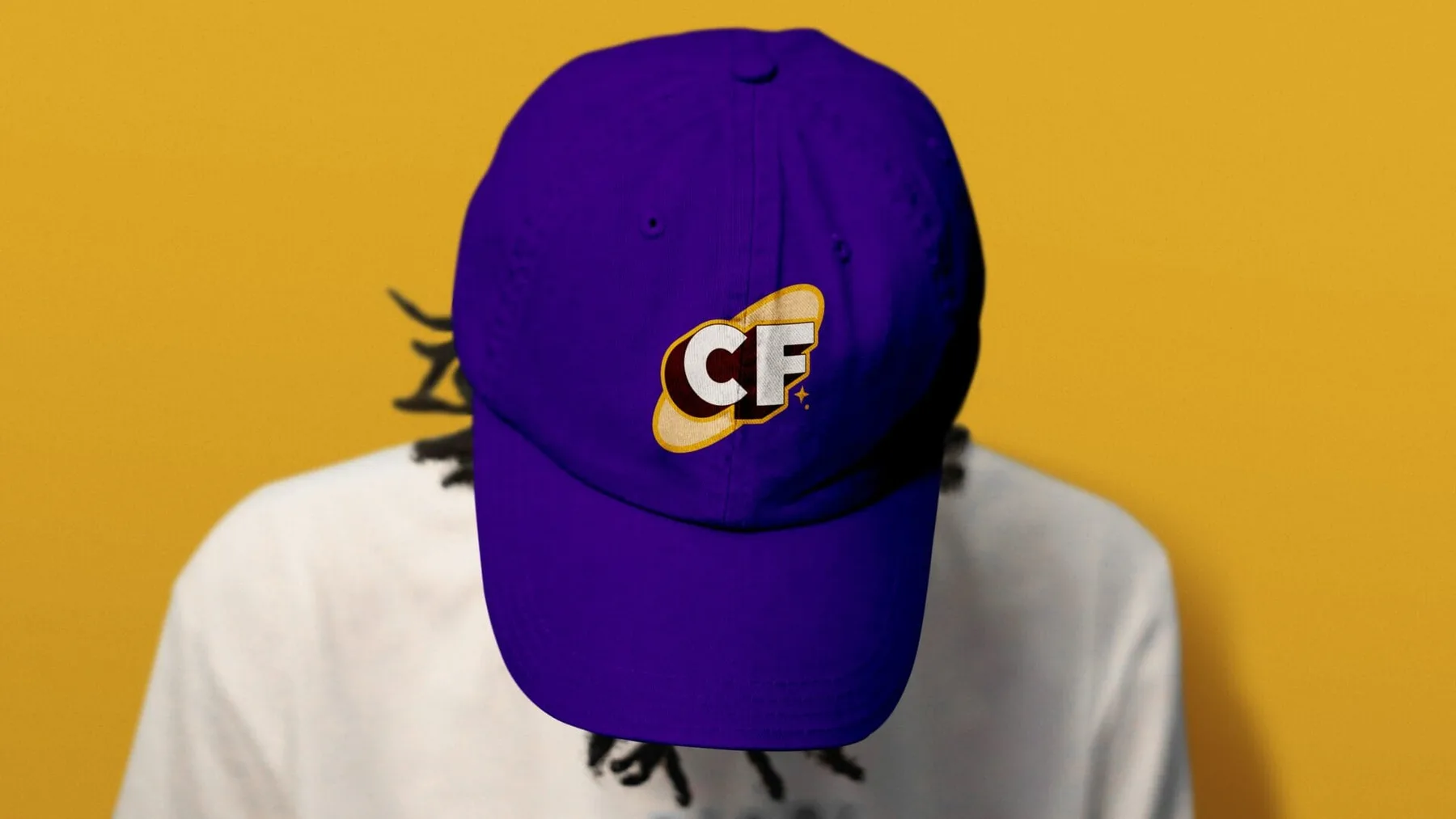 Purple CocoFro cap with the orbit mark against a yellow background