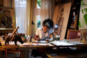 Young African-American artist at work in the studio. Creative person making art.